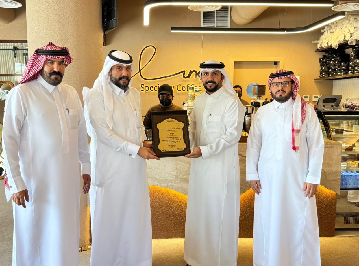 School administrators presenting a plaque to Lungo inside the café